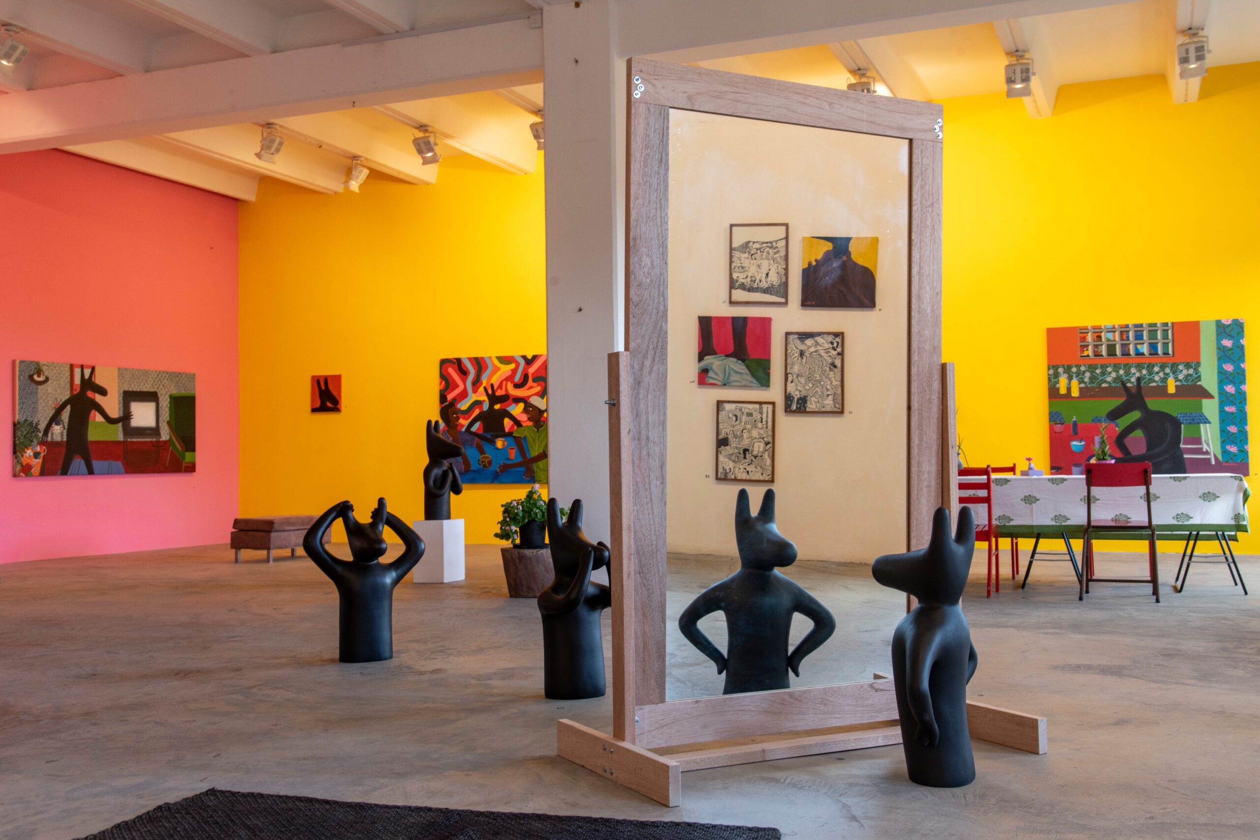 Bright art gallery with colourful paintings and sculptures.