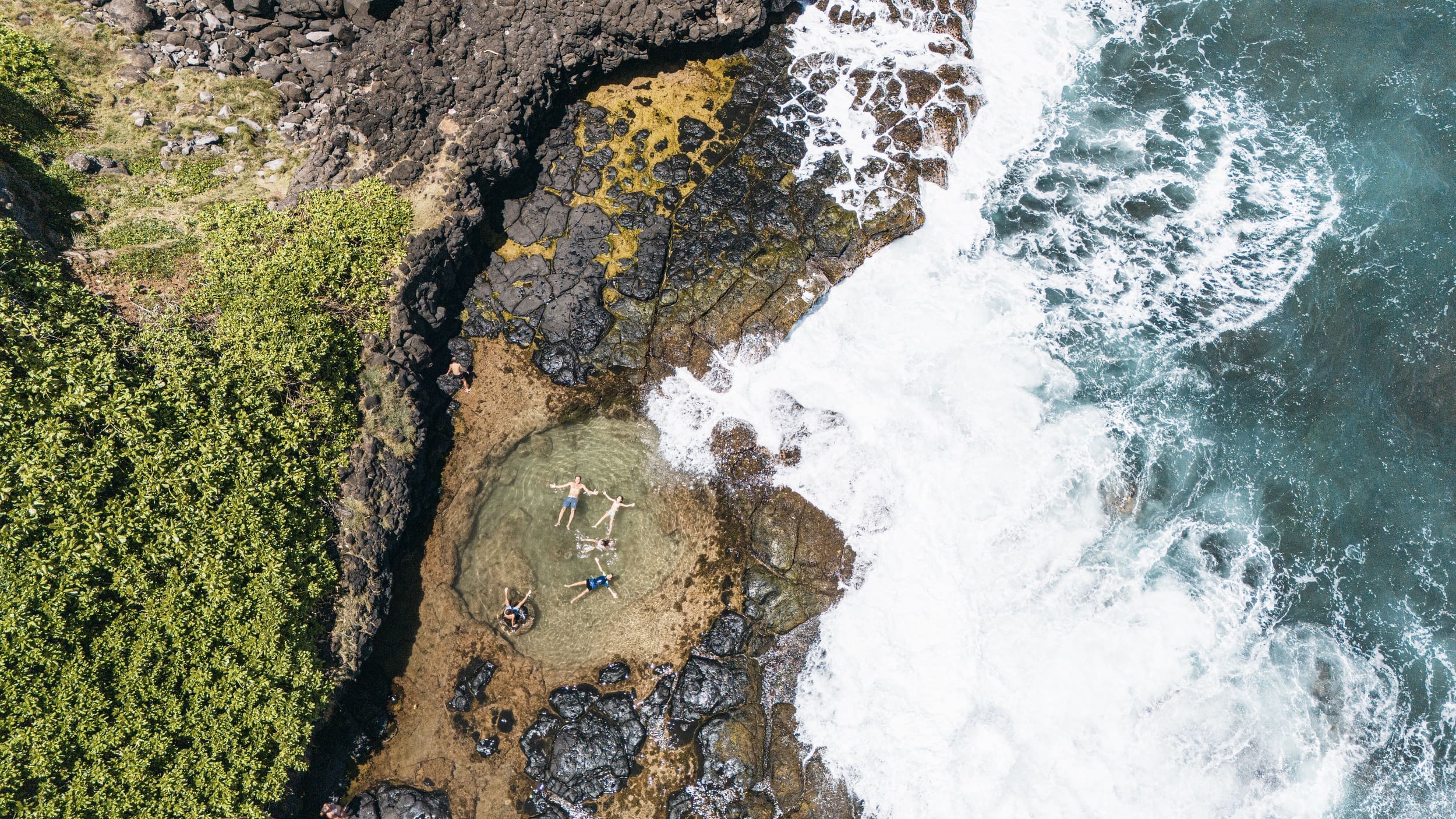 Aerial view of rocky shore and ocean waves.